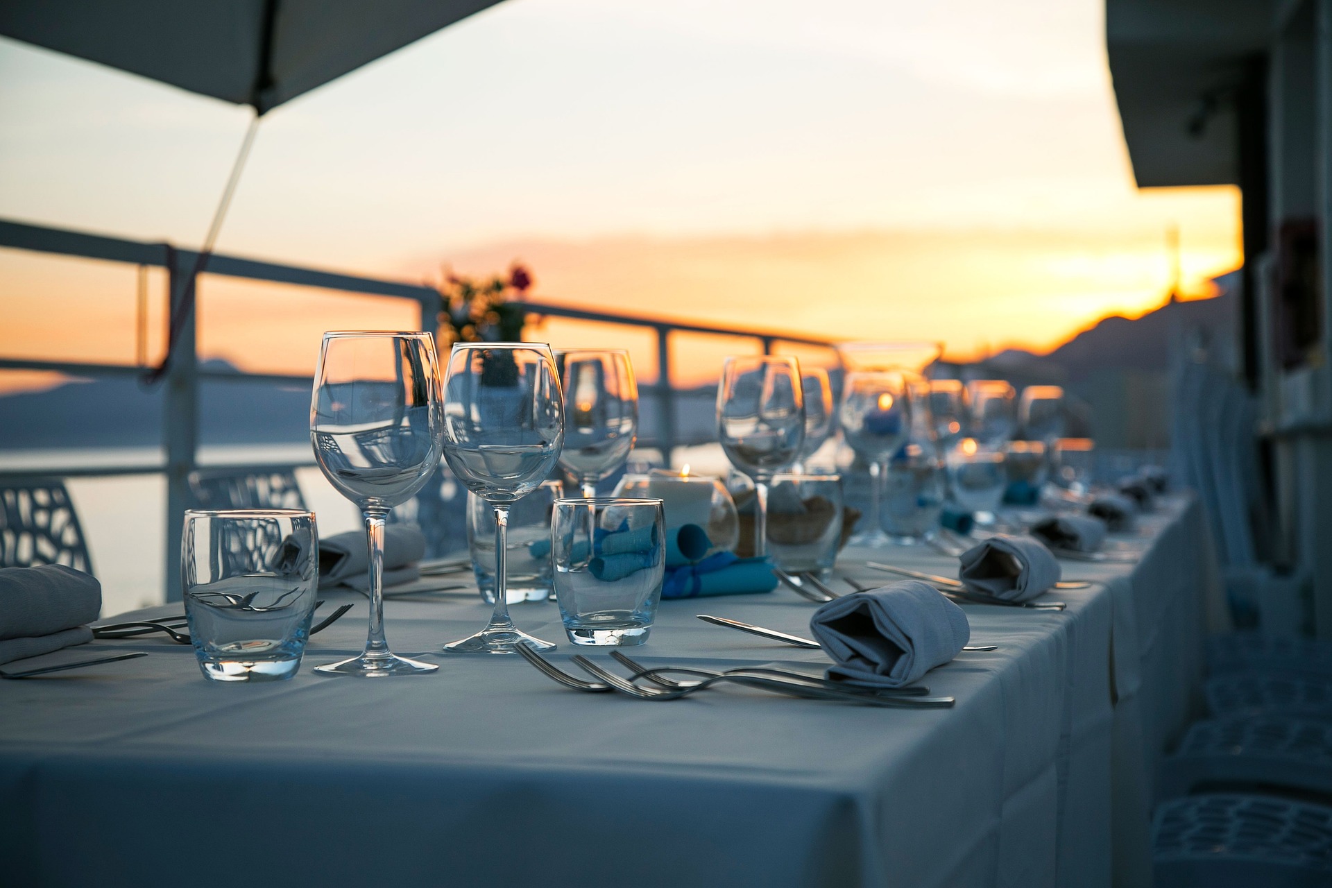 Seaside terrace dinner table set at sunset for an event seating plan