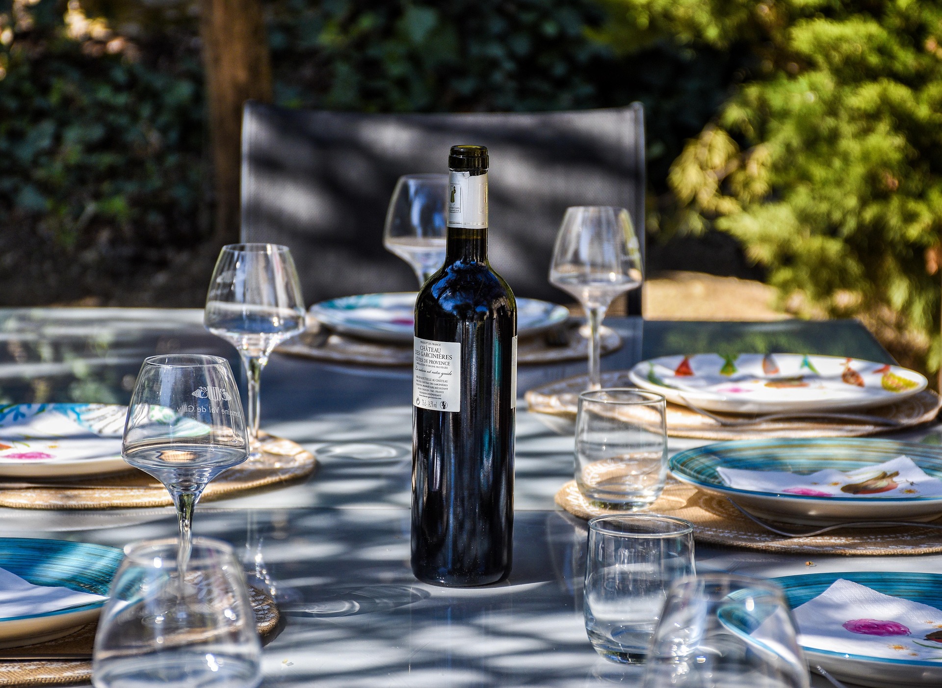Garden dinner table with wine and place settings for a small private event